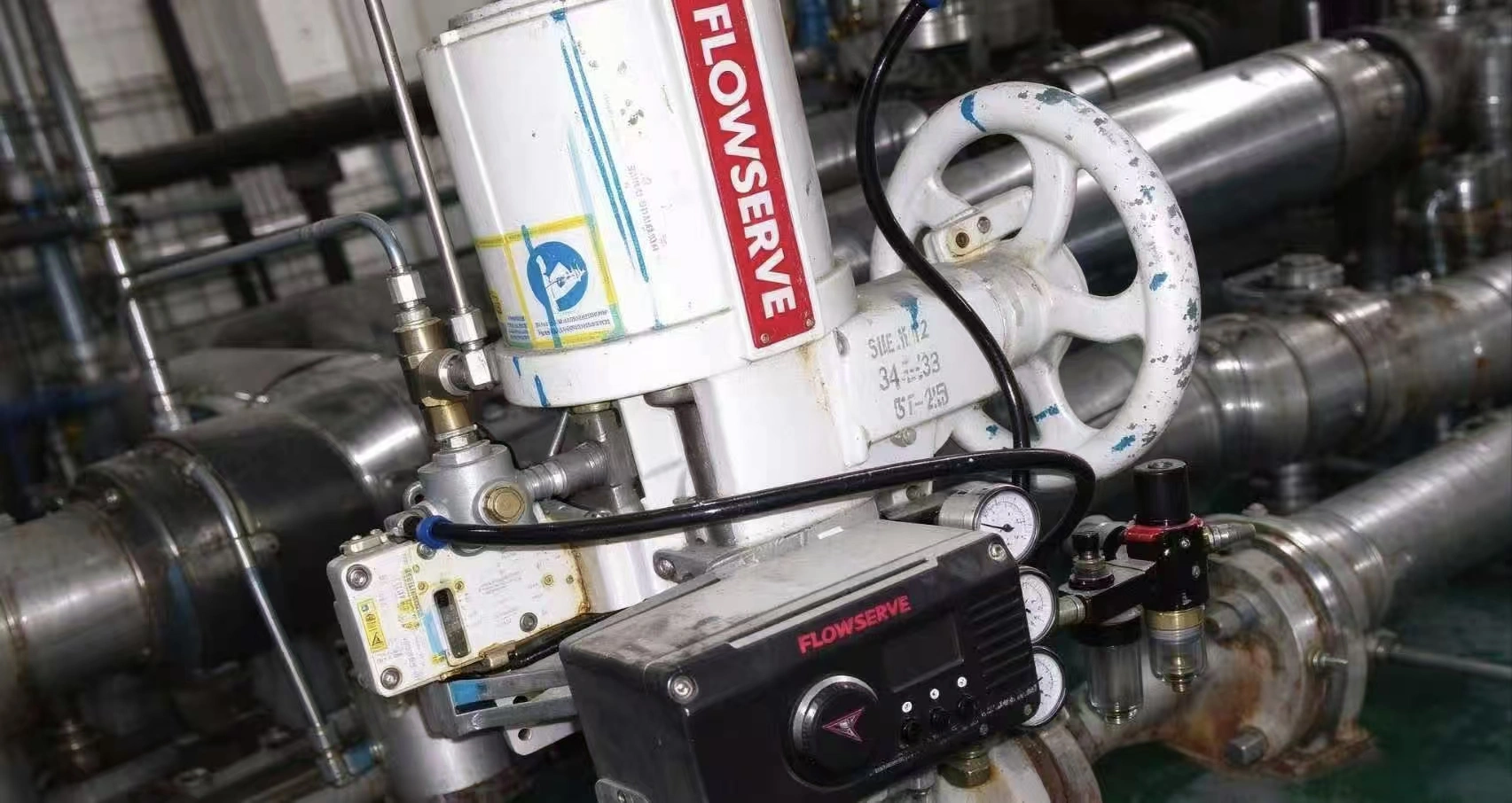 Valve positioner installed on a Flowserve control valve in an industrial application site.